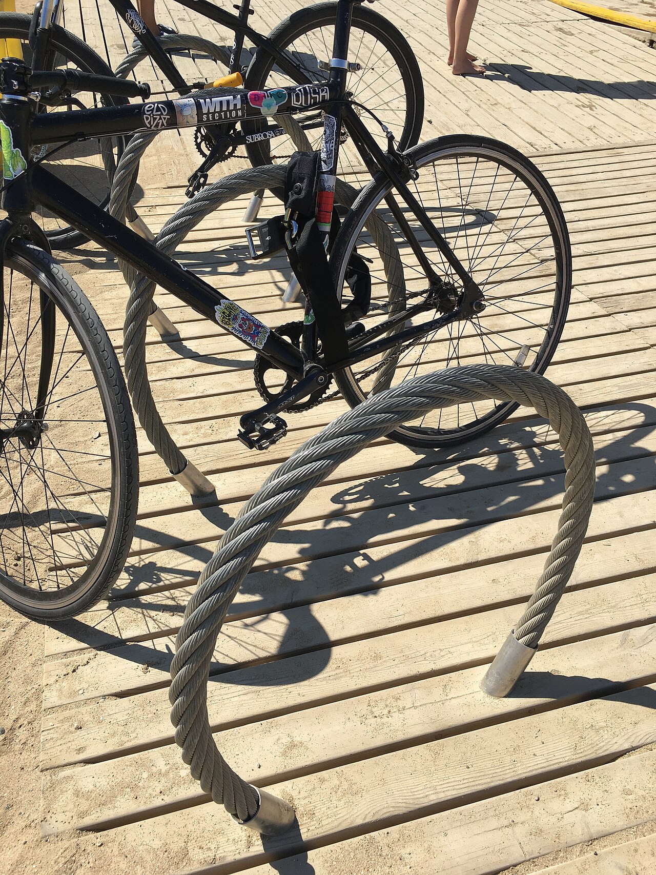 Bike rack in the form of massive steel cable rings at Barceloneta beach in Barcelona, Spain, 2022.