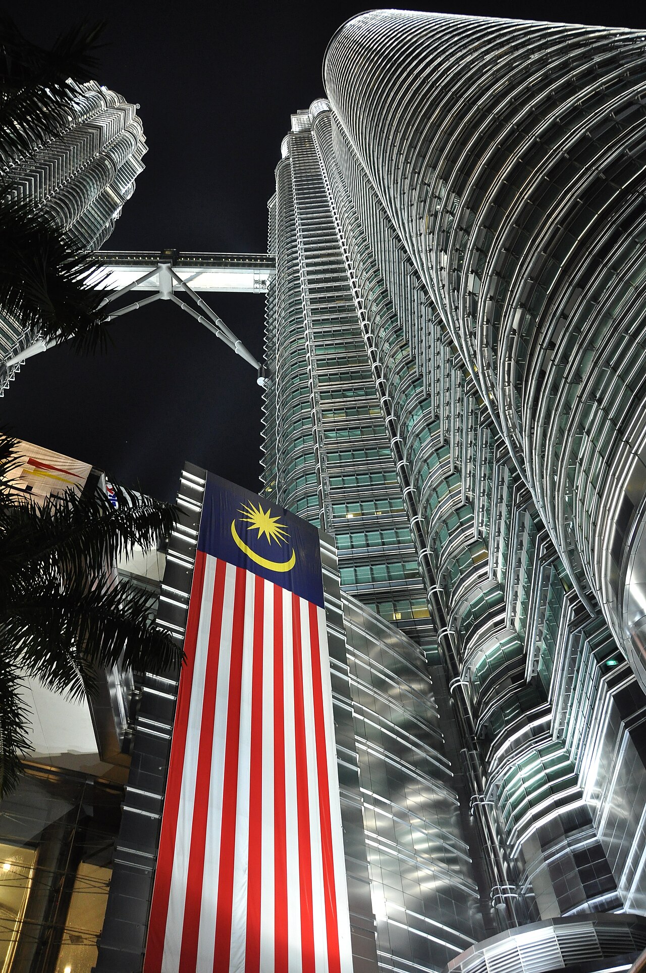 Petronas Towers, Kuala Lumpur, Malaysia. Photo taken at night from the base of one of the towers looking up towards the other tower. One of the large Malaysian 
